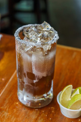 Natural Michelada with lemon and beer in a frozen glass jar.