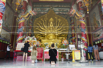 Thai peole praying Guanyin bodhisattva and Thousand Hands statue in Chinese shrine at Wat Muang