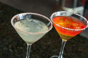 I count on some cocktails in a bar on a marble table on a black restaurant background.