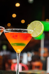 I count on some cocktails in a bar on a marble table on a black restaurant background.