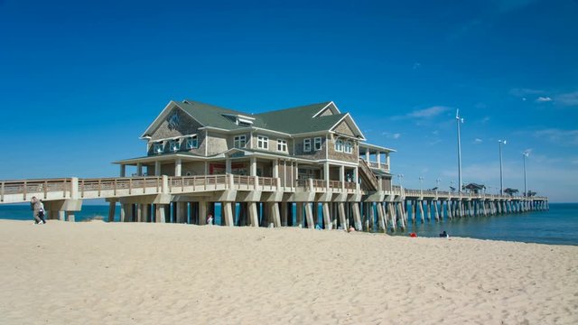 Jennette's Pier in Nags Head on the Outer Banks of North Carolina on a Sunny Day with Tourists Enjoying the Sandy Beach