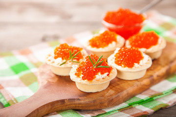 Tartlets with cheese and red caviar. Selective focus. Copy space