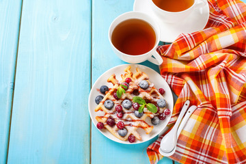 Homemade wafers with berries and tea on a table. Selective focus. Copy space.