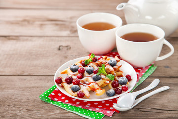 Homemade wafers with berries and tea on a table. Selective focus. Copy space.