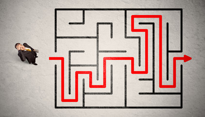 Lost businessman found the way in maze with red arrow