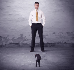 Fototapeta premium Angry big manager looking at small business man