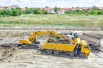 Excavator is loading a truck on building site