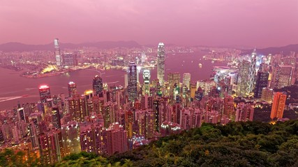 Obraz premium Hazy dusk scenery of Hong Kong viewed from Victoria Peak with city skyline of crowded skyscrapers by Victoria Harbour and Kowloon area ~ with air pollution level classified as 