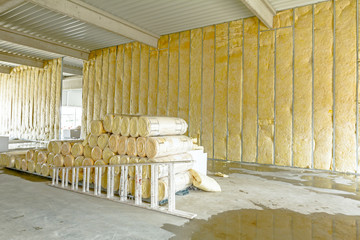 Package of thermal insulation material, rock wool is wrapped in foil. Used wooden ladder