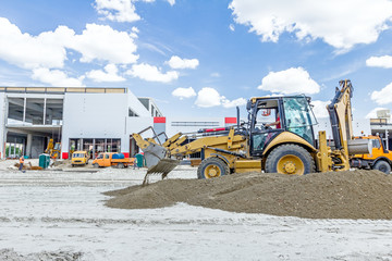 Excavator is unloading soil from his front bucket