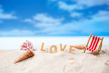 Fototapeta na wymiar valentine decoration with love wooden text and beach chair on white sand beach with tropical blue sea and clear blue sky,Image For Love Valentine Day or summer vacation Concept.