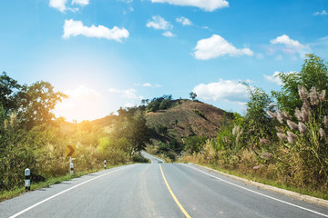 Asphalt road in the mountains and colorful sunrise with clear blue sky