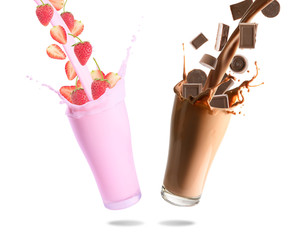 Verser des pépites de chocolat, du lait au chocolat, du lait de fraise et de fraise dans un verre avec des éclaboussures., Fond blanc isolé.