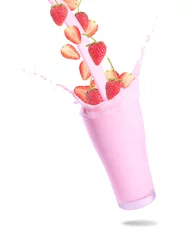 Pouring strawberry and strawberry milk into glass with splashing., Isolated white background.