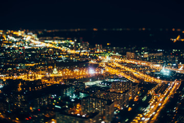 Fototapeta na wymiar True tilt shift shooting of VDNKh district of night Moscow from very high point: multiple buildings, main street of VDNKh in focus, strong bokeh in foreground and background, square with monument