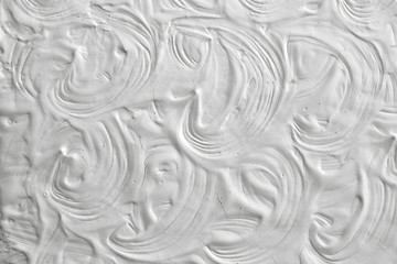 The texture of the plaster and putty on a white wall. The background for a festive greeting cards. Drawing with patterns of leaves.