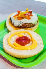 Homemade burgers for a picnic on a green plate.