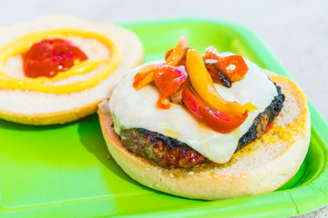 Homemade burgers for a picnic on a green plate.