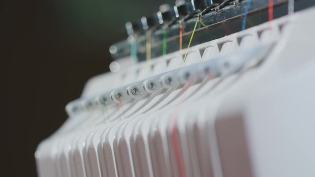 Hands Putting Knit in Needle to Embroidery Machine