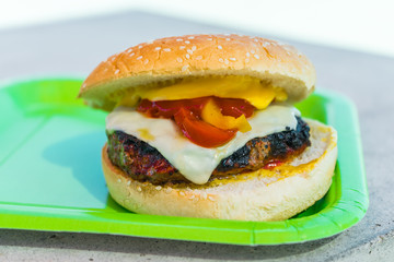Homemade burgers for a picnic on a green plate.