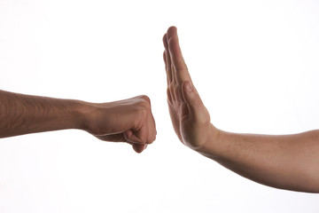 One hand preventing punch attack of another hand on isolate white background.