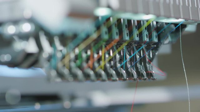 Hands Putting Knit in Needle to Embroidery Machine