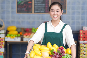 Obraz premium young pretty woman works in fruit store