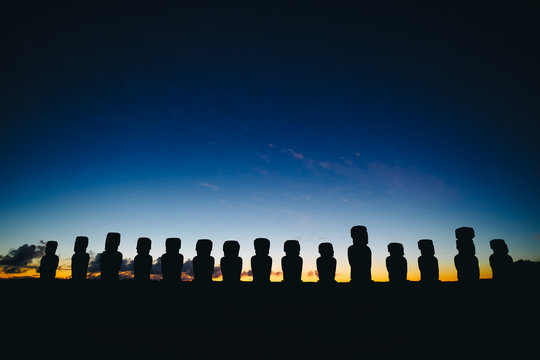 Fifteen standing moai on Ahu Tongariki against dramatic sunrise sky in Easter Island, Chile