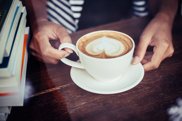 Woman's hands relaxing with coffee at cafe. Women lifestyle concept.
