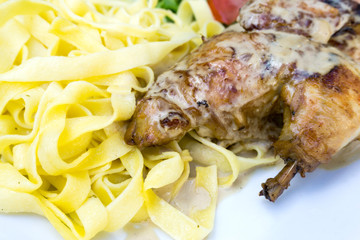 close-up of plate of pasta and chicken with lettuce