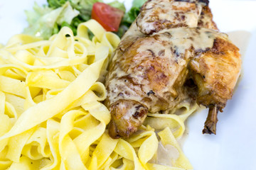 close-up of plate of pasta and chicken with lettuce