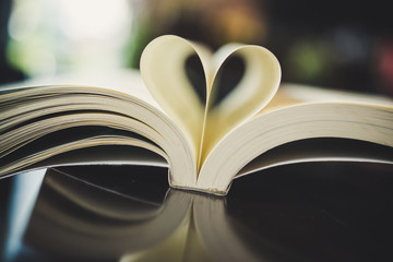 Curled paper heart shape with blurred bokeh of cafe.