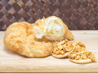 Croissant and cookies on cutting board close up