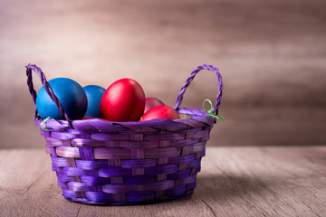 Egg basket on a vintage wooden background, happy easter