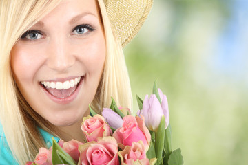 junge Frau mit Blumenstrauss und lachenden Gesicht