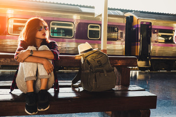young woman traveler wearing backpack waiting railway at train station, Summer holiday and travel...