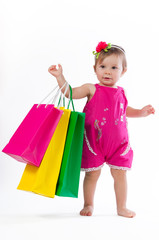 Little girl is surprised with colorful paper bags isolated on white background.