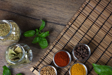 Various fresh spices in bowls, wooden background, 