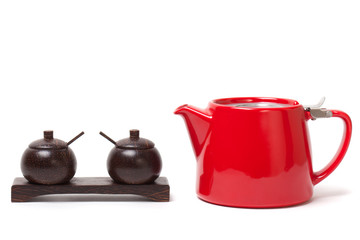 Red modern teapot and wooden containers to put the sugar, salt and other. isolated on white
