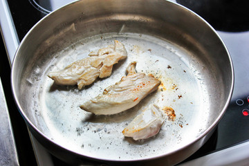 The meat is fried in a pan. chicken. Meat. The meat is frying. Electronic plate. Cooking. Kitchen. Tasty food. Close-up