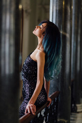 Fashion portrait of gorgeous girl with blue dyed hair long. The beautiful evening cocktail dress.