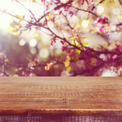 Empty wooden table over spring flowers tree background for product montage display