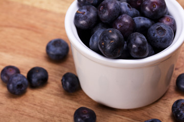 Pot of blueberries on a rustic background