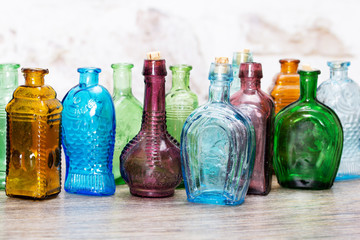 Coloured glass bottles on a rustic background - 139316450