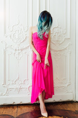 Fashion portrait of gorgeous girl with blue dyed hair long. The beautiful evening cocktail dress.
