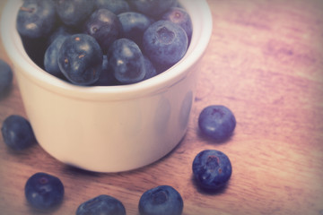 Pot of blueberries on a rustic background