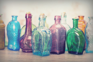 Coloured glass bottles on a rustic background