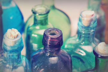 Coloured glass bottles on a rustic background