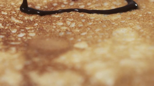 Slow motion of chocolate sauce pour over blini closeup, 180fps prores footage