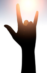 Obraz premium Raised hands catching sun on sunset sky. Concept of spirituality, wellbeing, positive energy etc.